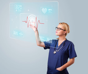Young nurse pressing modern medical type of buttons
