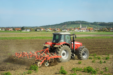 Bauer mit Traktor bei Bodenbearbeitung
