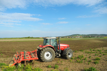 Traktor mit Egge und Cambridge Walzen am Feld