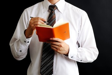メモを書くシャツの男性
