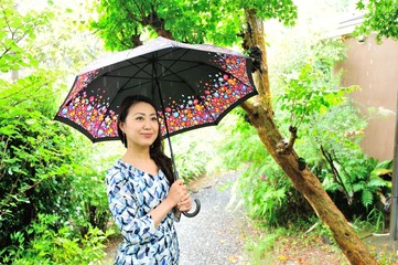 雨の日に傘を差している日本人の女性