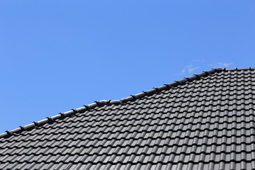 black tiles roof on a new house with blue sky