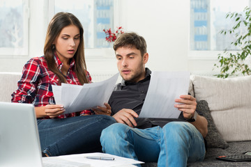 couple calculating their domestic bills at home