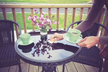 Woman setting table for tea outside