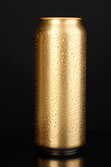 golden can with water drops isolated on black