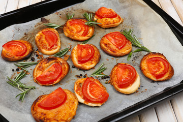 Small pizzas on baking paper close up
