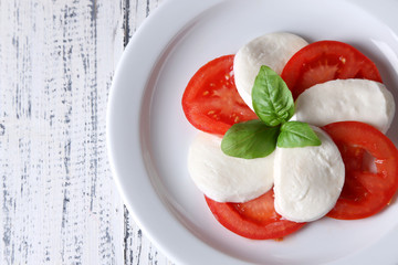Caprese salad with mozarella cheese, tomatoes and basil