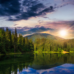 Fototapeta na wymiar pine forest and lake near the mountain at sunset