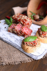 Composition with knife,  tasty sandwiches with salami sausage,