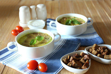 Tasty soup in saucepans on wooden table, close up