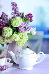 Composition with teapot,  mug and beautiful spring flowers in