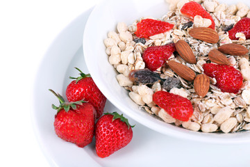 Healthy cereal in bowl with strawberries and nuts close up
