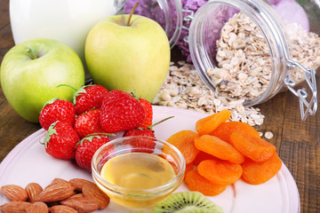 Healthy cereal with milk and fruits on wooden table
