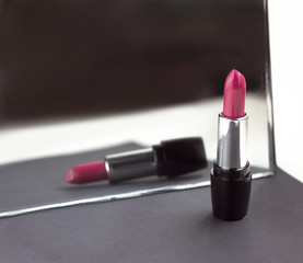 two red lipsticks, perfect versus imperfect symbolic concept ide