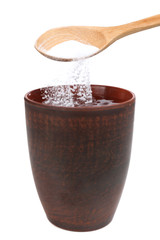 Spoon of baking soda over glass of water, isolated on white