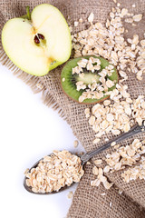 Apple, kiwi fruit with oatmeal and vintage spoon isolated