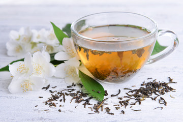 Cup of tea with jasmine on table close-up