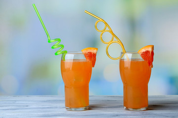 Grapefruit cocktail with cocktail straw on bright background