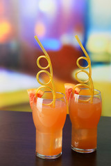 Grapefruit cocktail with cocktail straw on bright background