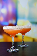 Grapefruit cocktail in glasses on bright background