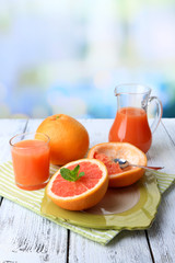 Half of grapefruit, glass jug with fresh juice and spoon