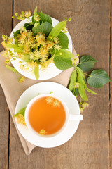 Tasty herbal tea with linden flowers on wooden table
