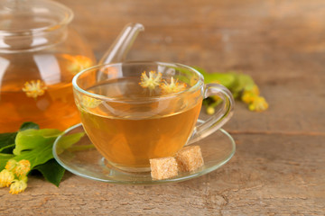 Tasty herbal tea with linden flowers on wooden table