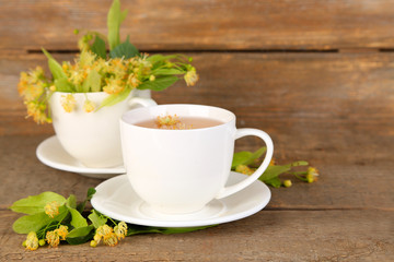 Tasty herbal tea with linden flowers on wooden table
