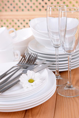 Set of white dishes on table on light background