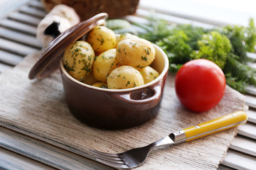Young boiled potatoes in pan on wooden table