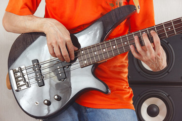 Fototapeta na wymiar Posing hands of the artist playing the bass guitar