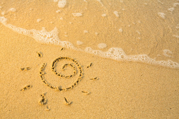 Fototapeta na wymiar Sun drawn on the beach texture - soft wave of the sea.