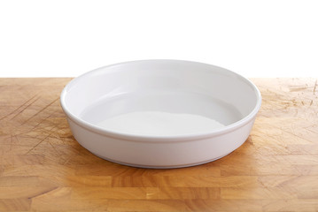 white ceramic bowl on wooden plate