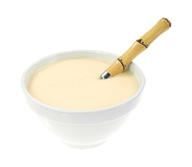 Cheese soup in an old bowl with spoon on a white background