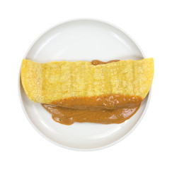 Corn tortilla filled with peanut butter on plate