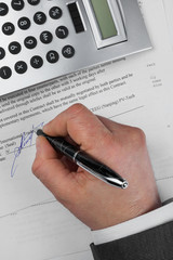 Businessman puts his signature on a document