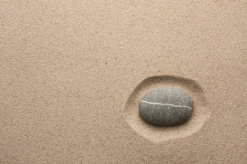Striped gray stone lying in the sand