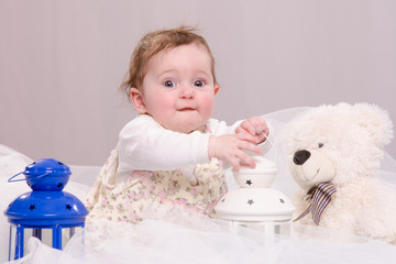 Six-month baby girl playing with toys on couch