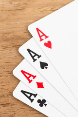 Four aces on wooden background