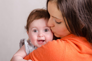 Mom kisses a six-month daughter