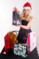 Blond woman in santa hat with shopping bags