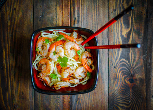 Pasta with grilled shrimps on wooden background