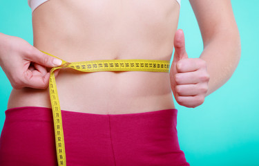 Diet. woman fit girl with measure tape measuring her waist