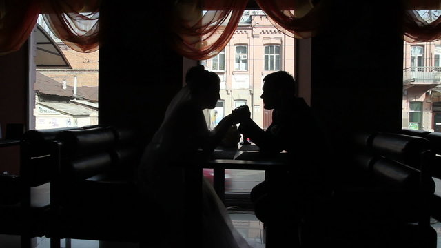 bride and groom in a cafe in backlit