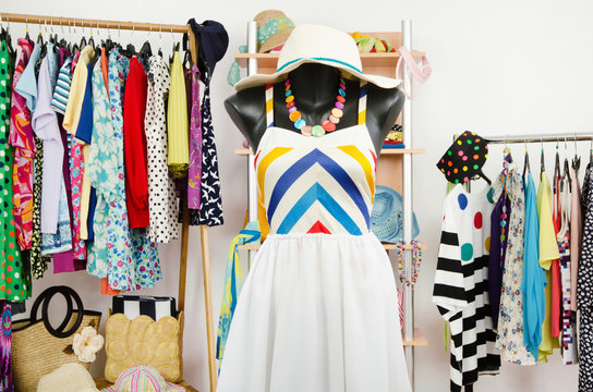 Wardrobe with summer clothes and a beach outfit on a mannequin.