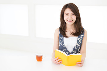 部屋で本を読む女性