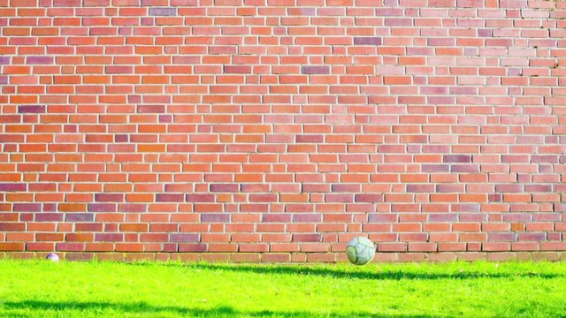 soccer ball near a brick wall