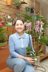 Crédence de cuisine en verre imprimé Fleuriste mature woman chooses  orchid