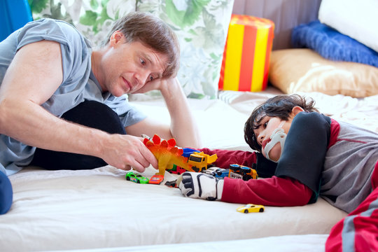 Handsome father playing cars with disabled son