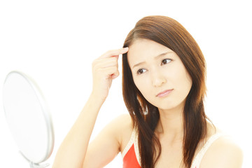 顔のシミを気にする女性